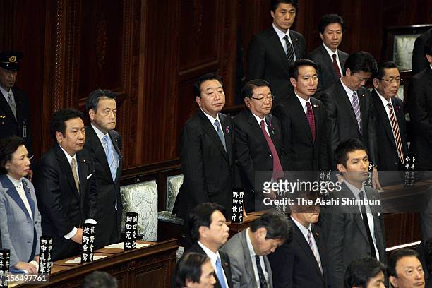 Japanese Prime Minister Yoshihiko Noda and other House of Representatives members stand up to vote for the bill to eliminate five single-seat...