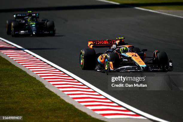 Lando Norris of Great Britain driving the McLaren MCL60 Mercedes leads Lewis Hamilton of Great Britain driving the Mercedes AMG Petronas F1 Team W14...