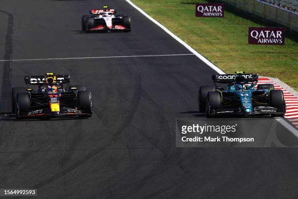 Sergio Perez of Mexico driving the Oracle Red Bull Racing RB19 and Fernando Alonso of Spain driving the Aston Martin AMR23 Mercedes battle for track...