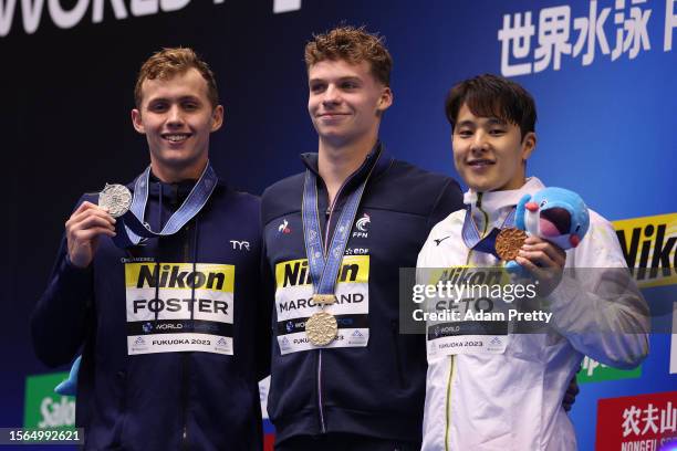 Silver medallist Carson Foster of Team United States , gold medallist Leon Marchand of Team France and bronze medallist Daiya Seto of Team Japan pose...