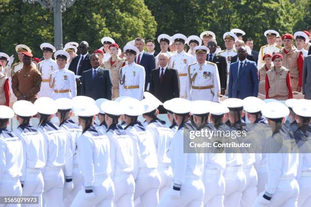 Russian President Vladimir Putin , Burkina Faso President Ibrahim Traore and Republic of Congo President Dennis Fassou Nguesso look at naval officers...