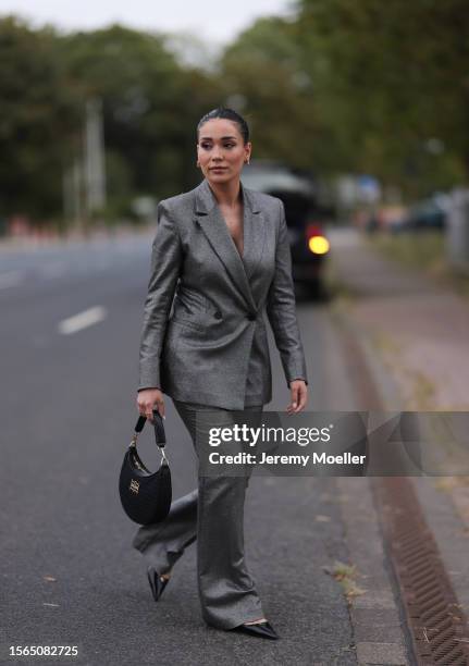 Betül Akbaba is is seen wearing a silver/glitter two-piece suit from Riani consisting of a buttoned blazer and suit pants, a black bag from Riani and...