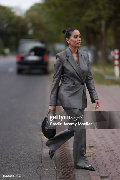 Betül Akbaba is is seen wearing a silver/glitter two-piece suit from Riani consisting of a buttoned blazer and suit pants, a black bag from Riani and...
