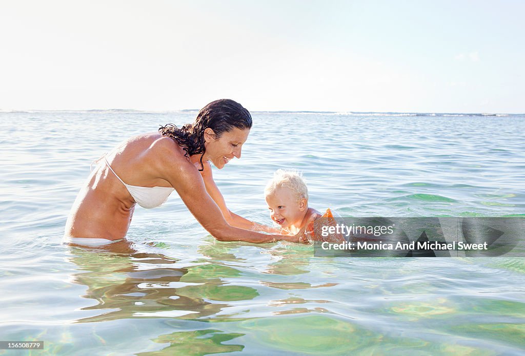 Happy mother and son having fun at the beach