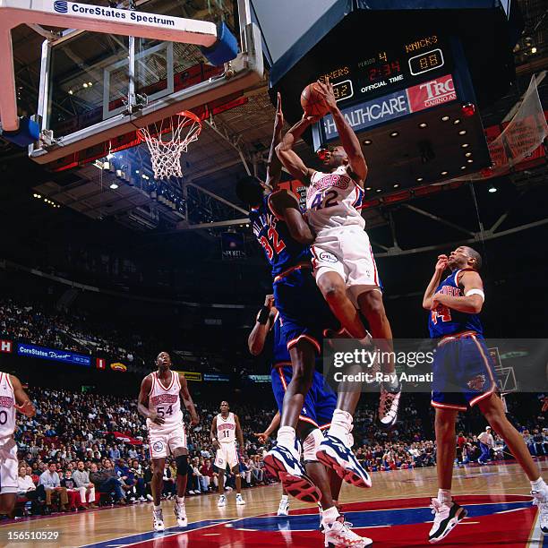 Jerry Stackhouse of the Philadelphia 76ers shoots the ball against Herb Williams of the New York Knicks during a game played circa 1996 at the...