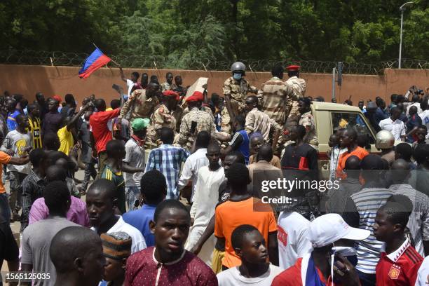 Protesters cheer Nigerien troops as they gather in front of the French Embassy in Niamey during a demonstration that followed a rally in support of...