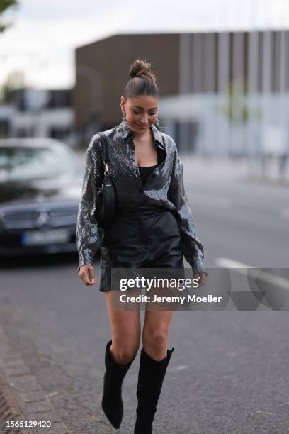 Catharina Marie Maranca is seen wearing a black sequins shirt from Riani, underneath a black top, black leather shorts from Riani, a black bag from...