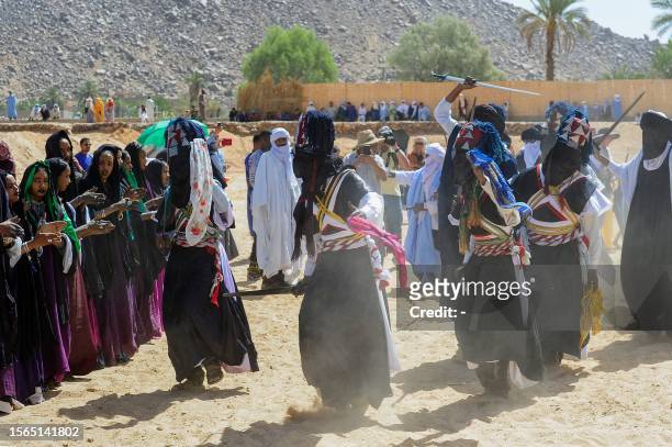 Men and women perform a traditional dance during the Sebeiba Festival, a yearly celebration of Tuareg culture, in the oasis town of Djanet in...