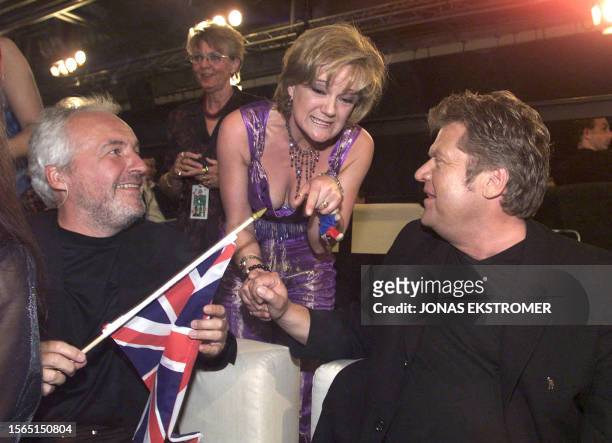 Danish brothers Jorgen and Niels Olsen are congratulated by UK singer Nicki French after the Danes' song "Fly on the Wings of Love" won the 2000...
