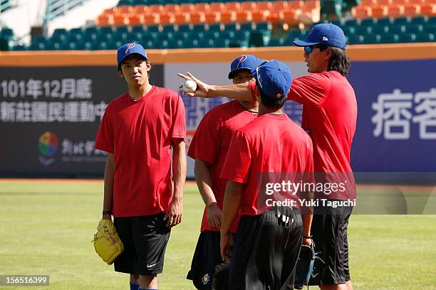 Geno Espinelli of Team Philippines discusses the circle change-up with teammates during the workout day for the 2013 World Baseball Classic Qualifier...