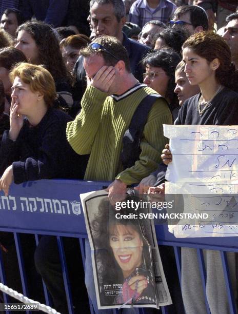 Fans of Israeli singer Ofra Haza mourn as they stand in front of her coffin at a pre-funeral ceremony in Tel Aviv 24 February 2000. The coffin,...