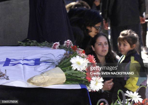 Fans of Israeli singer Ofra Haza mourn next to her coffin at a pre-funeral ceremony in Tel Aviv 24 February 2000. The coffin, draped in the Israeli...