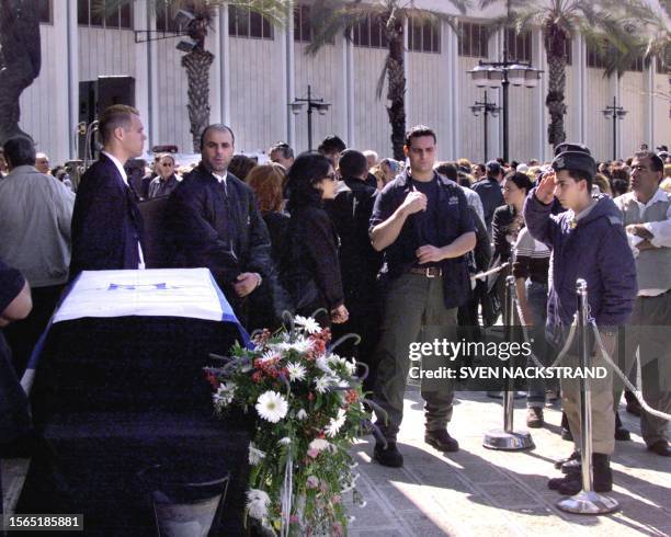 An Israeli soldier salutes in a last farewell to Israeli singer Ofra Haza at a pre-funeral ceremony in Tel Aviv 24 February 2000. The coffin, draped...