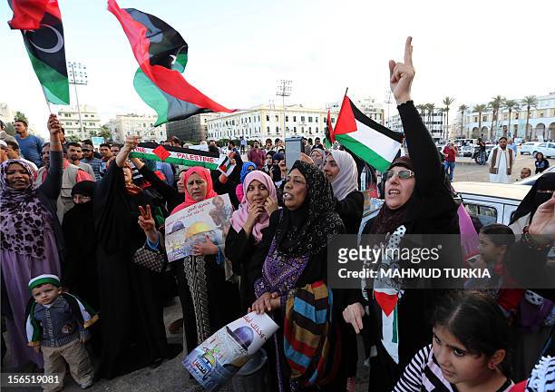 Libyan protesters, carrying the Palestinian and Libyan flags, shout slogans during a march in solidarity with Gaza in Tripoli's Martyrs Square on...