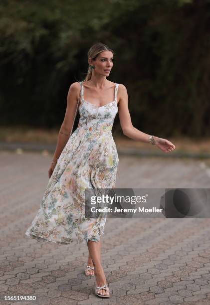 Annika Gassner is seen wearing a pastel floral midi dress, a beige bag and glitter pumps outside during the Riani Cruise 2023 on July 22, 2023 in...