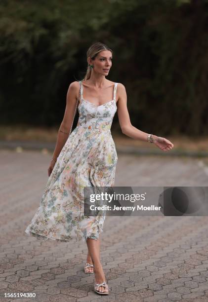 Annika Gassner is seen wearing a pastel floral midi dress, a beige bag and glitter pumps outside during the Riani Cruise 2023 on July 22, 2023 in...
