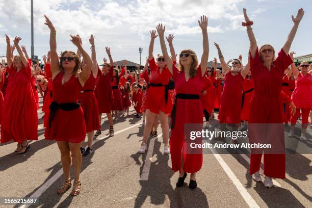 Hundreds of Kate Bush fans came together wearing red dresses on Folkestone's Harbour Arm to dance to her most iconic song, Wuthering Heights on the...