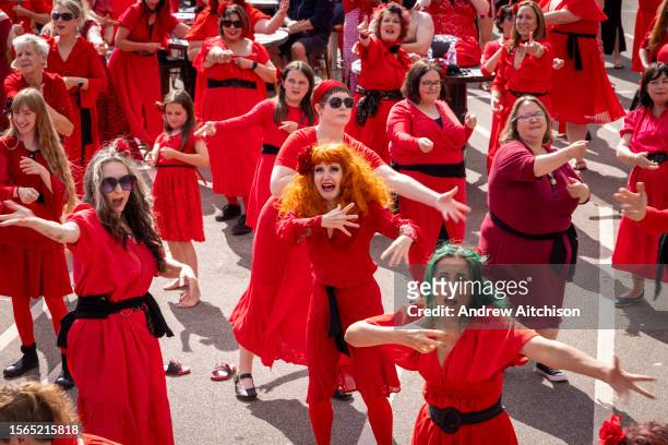Hundreds of Kate Bush fans came together wearing red dresses on Folkestone's Harbour Arm to dance to her most iconic song, Wuthering Heights on the...