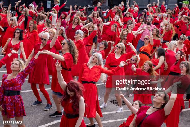 Hundreds of Kate Bush fans came together wearing red dresses on Folkestone's Harbour Arm to dance to her most iconic song, Wuthering Heights on the...