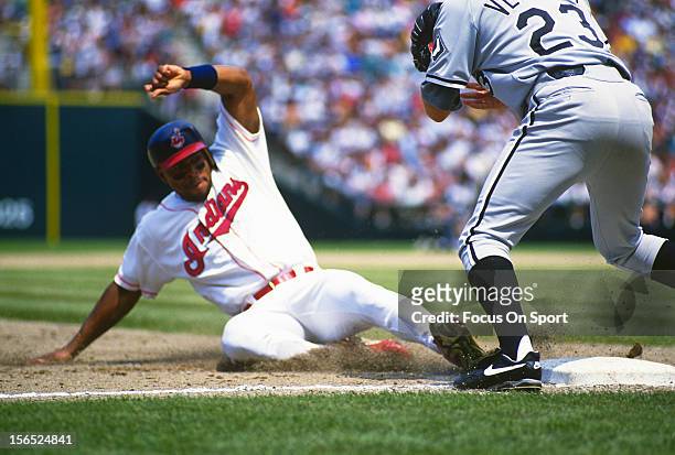 Albert Belle of the Cleveland Indians slides into third base safe against the Chicago White Sox during an Major League Baseball game circa 1994 at...