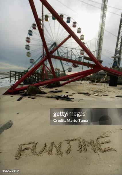 Funtime" is scrawled in the sand in front of destroyed amusements from the Funtown Pier on November 16, 2012 in Seaside Heights, New Jersey. Two...