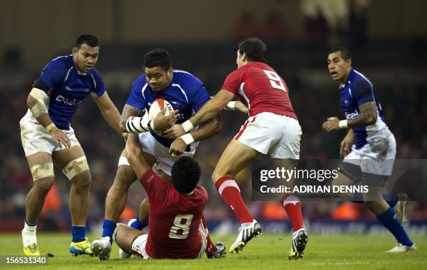 Samoa's Iosefa Tekori breaks through a tackle from Wales' Toby Faletau and Mike Phillips during their International Rugby Union match at The...