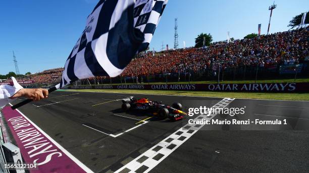 Max Verstappen of the Netherlands driving the Oracle Red Bull Racing RB19 takes the chequered flag during the F1 Grand Prix of Hungary at Hungaroring...