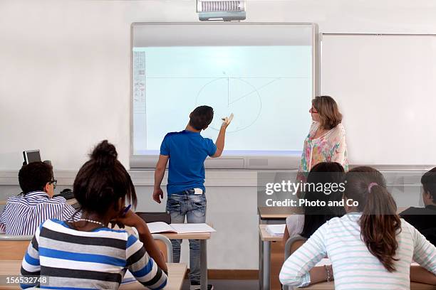 teeneger in classroom with interactive white board - projector classroom photos et images de collection