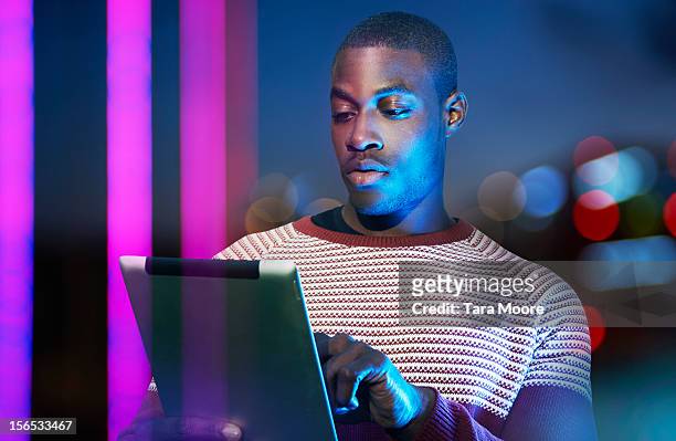 man using digital tablet at night in city - illuminated light stock pictures, royalty-free photos & images