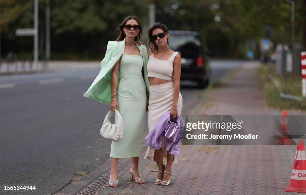 Lena Meckel is seen wearing a mint midi dress from Riani, a white leather bag and pumps with a glitter bow. Besides her, Anna Julia Antonucci is seen...