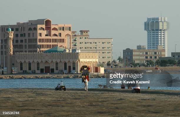 Camel decorated with flowers and rugs awaiting customers for a ride by the beachside in the Corniche district of Jeddah on late afternoon. Saudis...