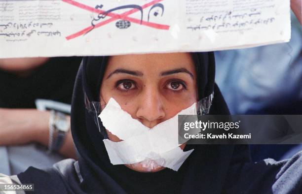 Female student demonstrates against censorship at Tehran university, after reformist newspapers were closed down. She holds a copy of the newspaper...