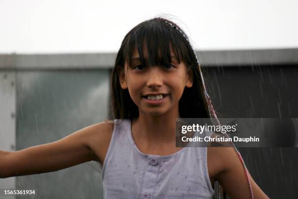 a mixed-race teenager feels raindrops on his face. - temps qu'il fait stock-fotos und bilder