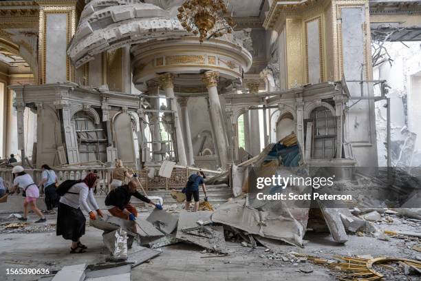 Ukrainians clear away debris after a Russian missile struck the historic Holy Transfiguration Cathedral in central Odesa, Ukraine, on July 23, 2023....