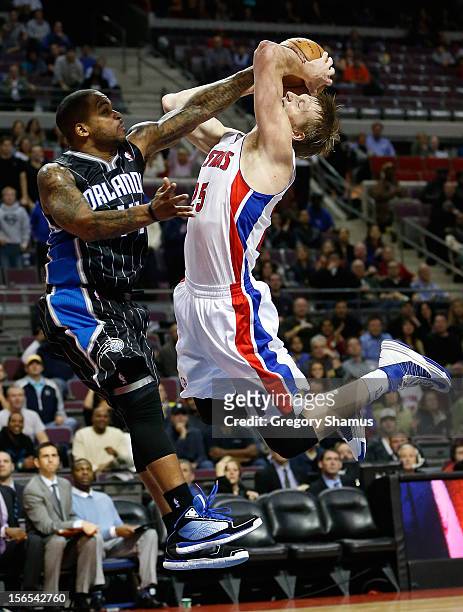Kyle Singler of the Detroit Pistons tries to get a shot off against Jameer Nelson of the Orlando Magic at the Palace of Auburn Hills on November 16,...