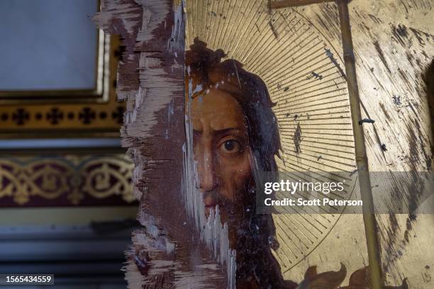 Damaged gilt Orthodox painting of Jesus Christ stands against a wall, as Ukrainians clear away debris after a Russian missile struck the historic...