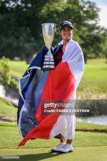 France's Celine Boutier, wrapped in a French flag, poses with her trophy after winning the Evian Championship, a women's LPGA major golf tournament...