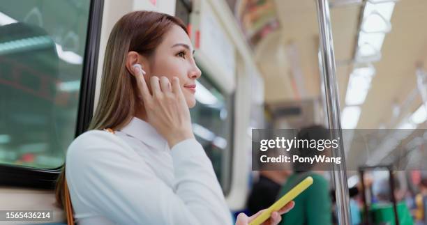 frau hören musik mit ohrstöpseln - in ear headphones stock-fotos und bilder