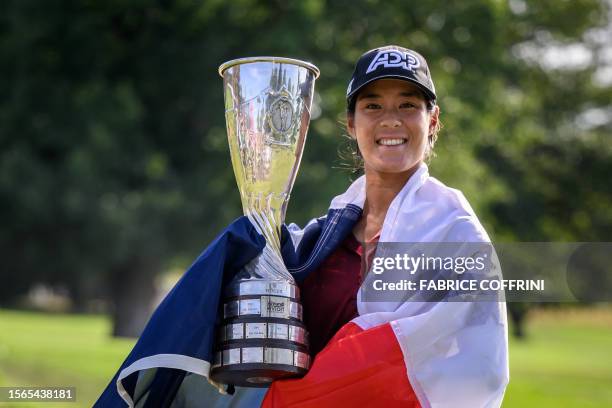 France's Celine Boutier, wrapped in a French flag, poses with her trophy after winning the Evian Championship, a women's LPGA major golf tournament...