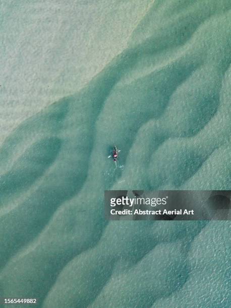 drone image looking down on a kayaker in the noosa river, queensland, australia - abstract seascape stock pictures, royalty-free photos & images