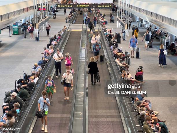 Travellers walk through Denver International Airport in Denver, Colorado, on July 30, 2023.