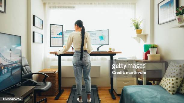 frau im home office läuft auf dem laufband unter dem schreibtisch - businesswoman under stock-fotos und bilder