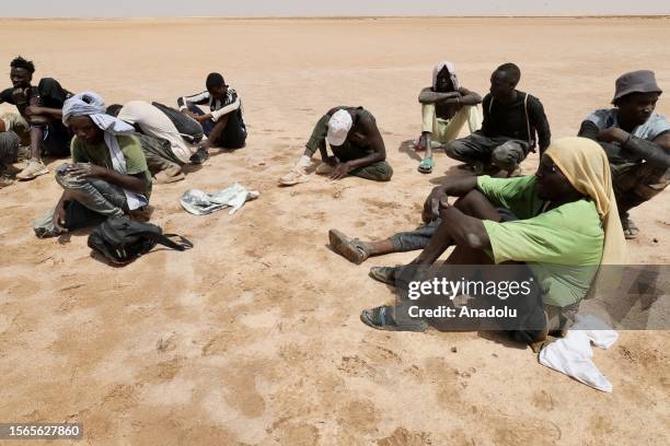 African irregular migrants stranded near the Libya-Tunisia border about 170 km from the capital Tripoli, await under high temperatures on July 30,...