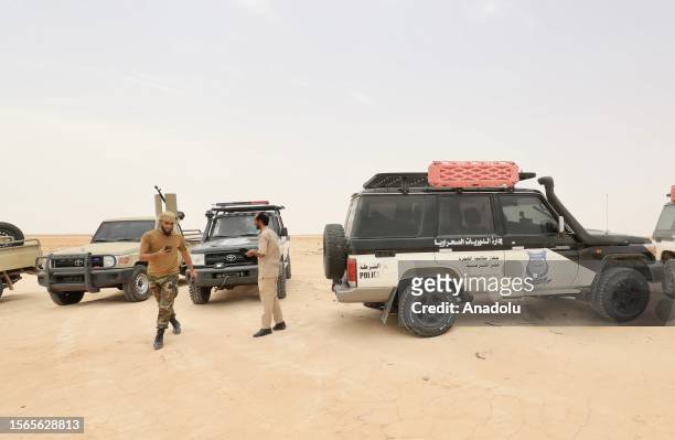 Libyan officials patrol as African irregular migrants stranded near the Libya-Tunisia border about 170 km from the capital Tripoli, await under high...