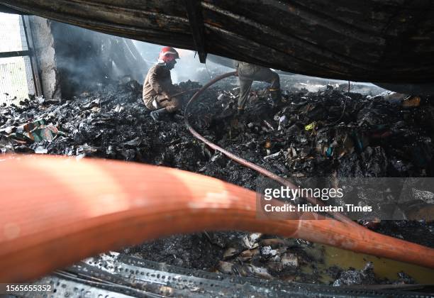 Firemen douse the fire that broke out at a footwear factory in west Delhi's Udyog Nagar near Peera Garhi Chowk in the morning, on July 30, 2023 in...