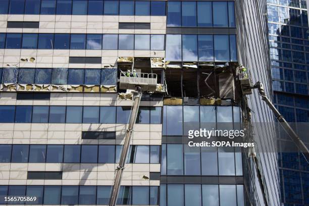 City workers use cranes to clean up the debris at the sight of another explosion in the Moscow City business center. The facade of the building...