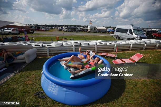 Fans float in a pool in the campgrounds area during the NASCAR Cup Series HighPoint.com 400 at Pocono Raceway on July 23, 2023 in Long Pond,...