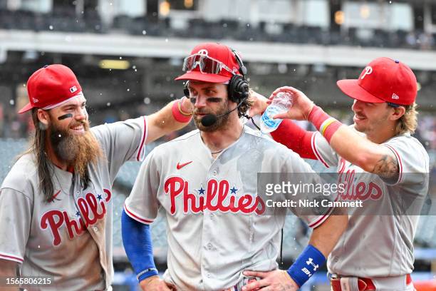 Brandon Marsh and Bryson Stott of the Philadelphia Phillies dump water on Bryce Harper during a post game interview as they celebrate the team's 8-5...
