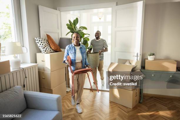 young couple with boxes moving  in new home - young couple moving house stock pictures, royalty-free photos & images