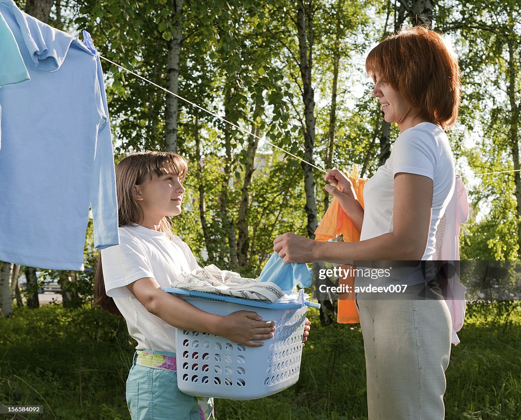 Mother and daughter hanging laundry